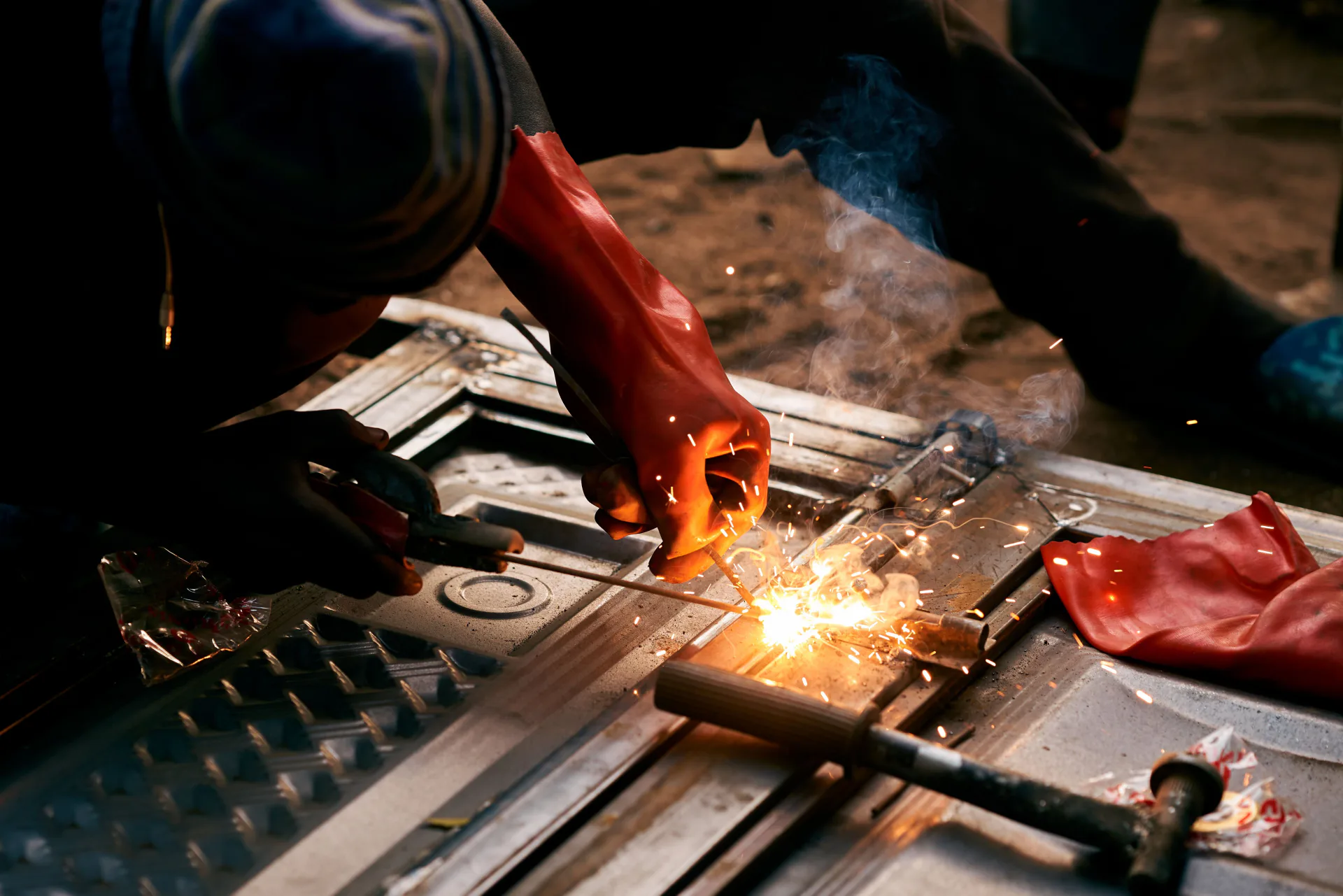 Welder practicing shielded metal arc welding on a steel workpiece during hands-on training