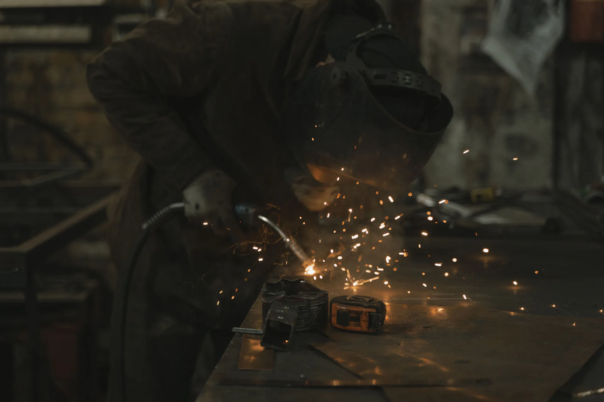Welder working at a fabrication table during practical wire-feed welding training